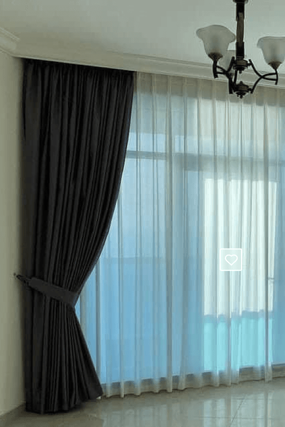 Blackout and sheer curtains layered on a bright window